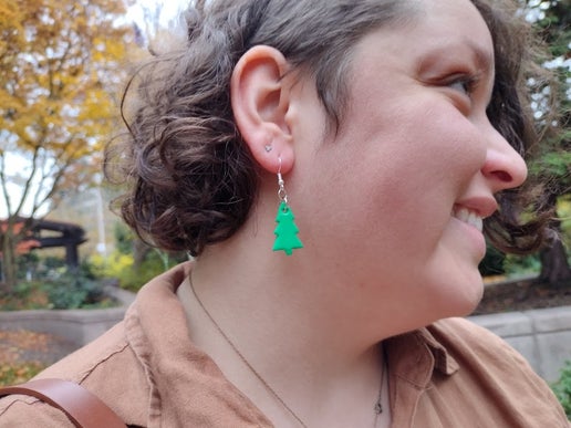 Woman wearing Christmas tree earrings