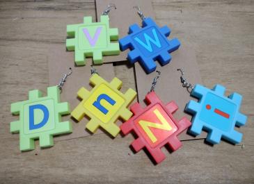 Three sets of Upcycled Letter Earrings on display cards